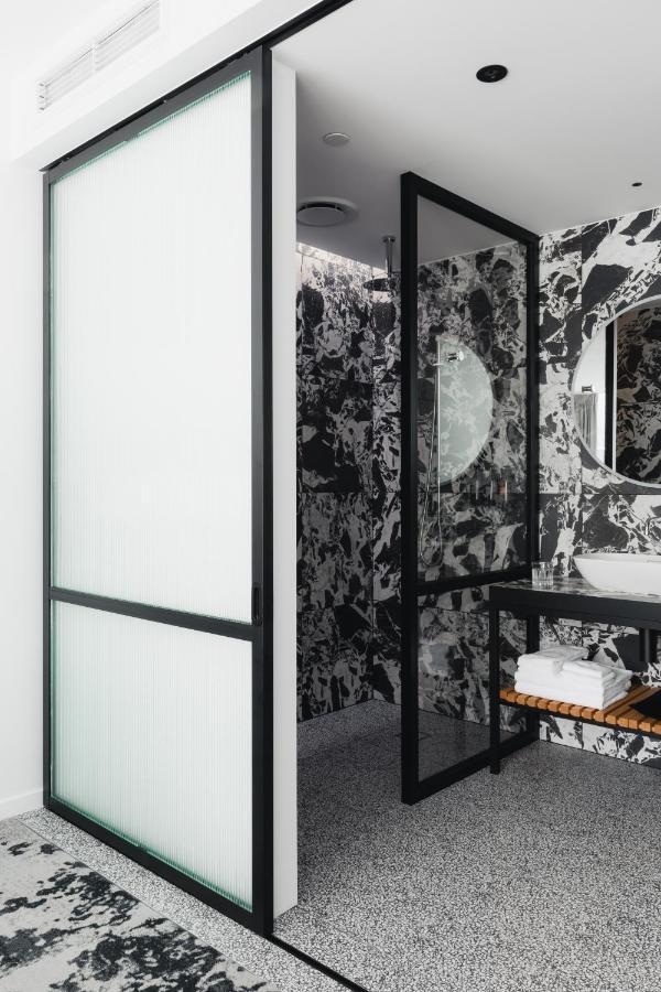 Ebb-Dunedin Esterno foto A shower enclosure with a frosted glass door