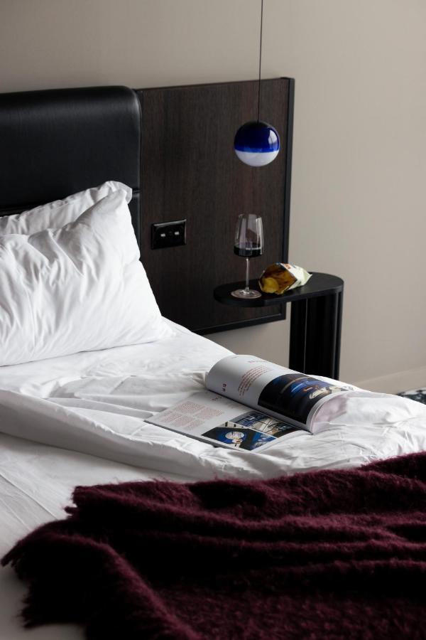 Ebb-Dunedin Esterno foto A bed with a magazine and a wine bottle